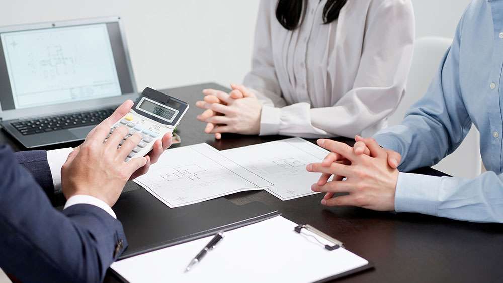 Real Estate agent calculates the pricing of a home for sale with the owners
