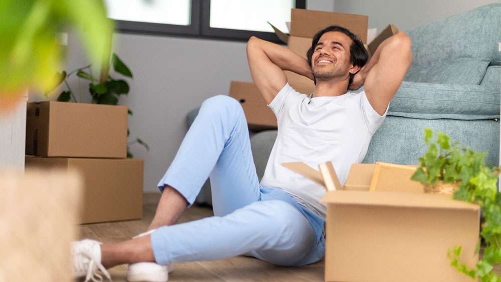 Young man takes a break from moving into his new home