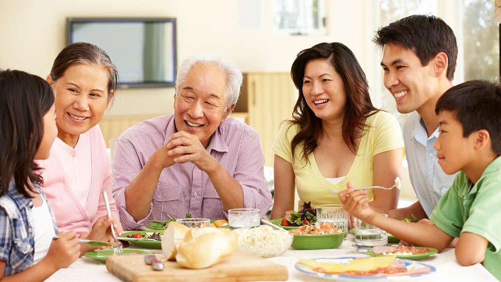 A multigenerational Asian family sharing a meal at home